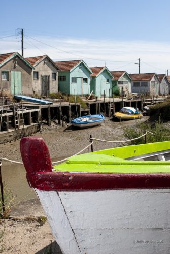 Le chenal à marée basse bordé de cabanes ostréicoles