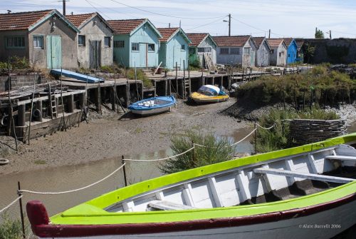 Le chenal à marée basse bordé de cabanes ostréicoles